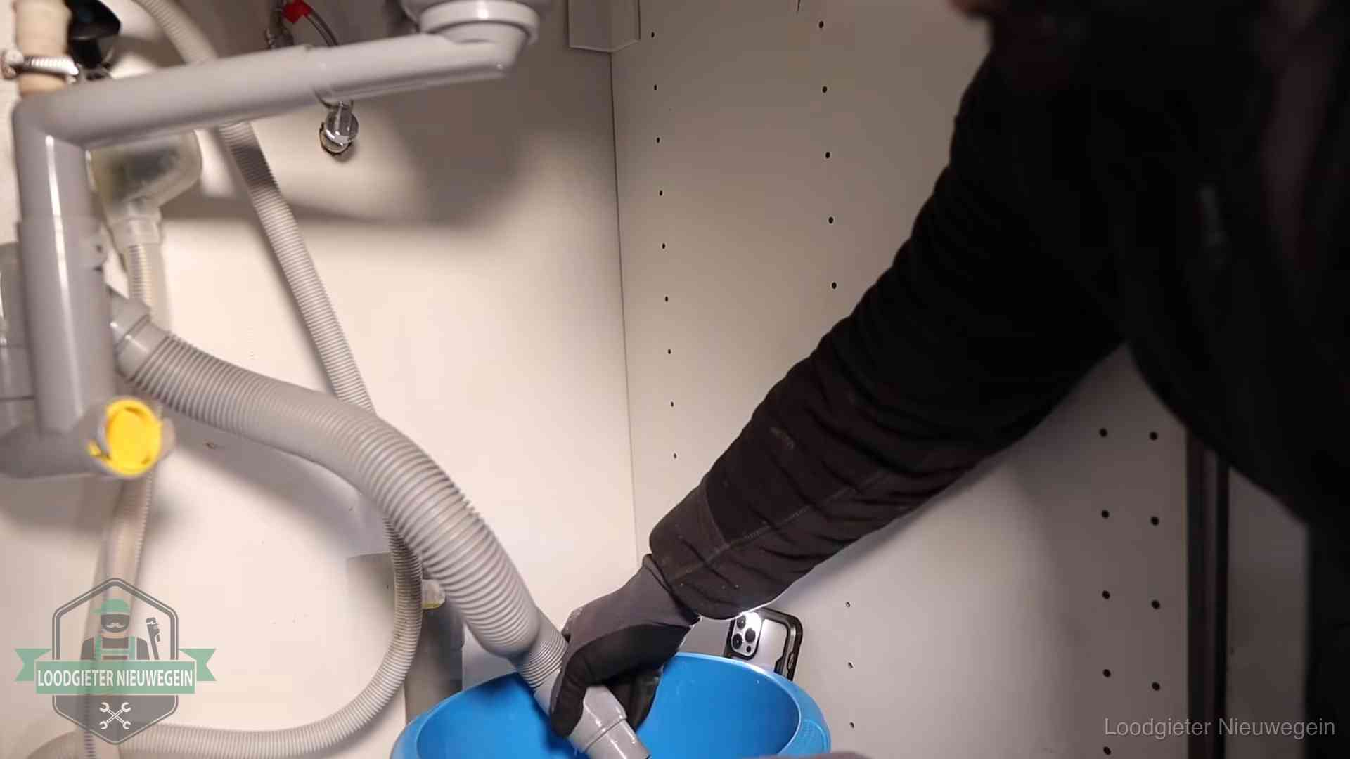 Afvoerslang loopt leeg in een emmer onder de gootsteen in Nieuwegein, een klus die je zelf kunt doen