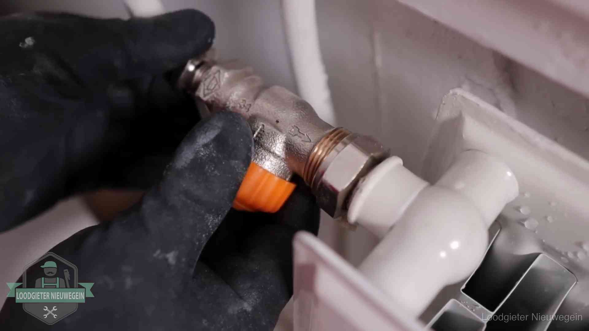 Thermostaatkraan wordt gemonteerd op een radiator in Nieuwegein voor het stookseizoen