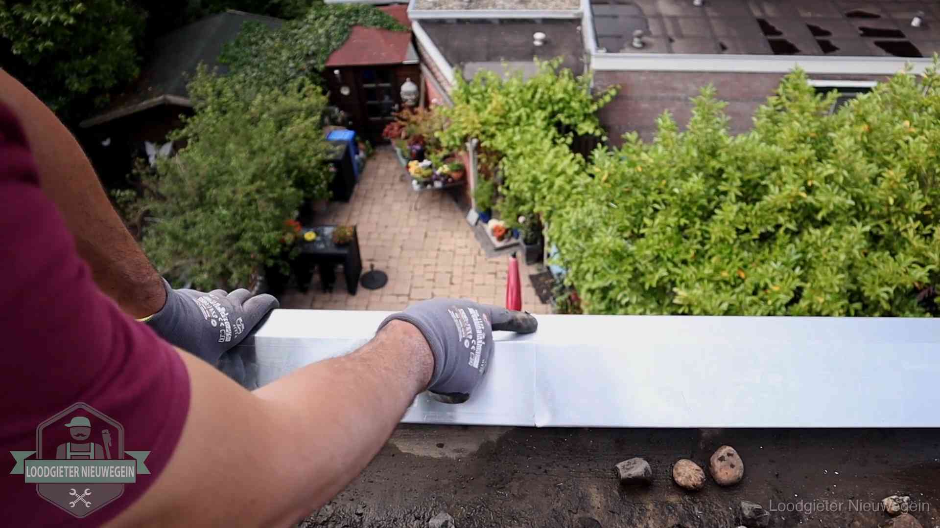 Daklekkage geregeld in Nieuwegein Vakman plaatst een daktrim op de dakrand van een woning in Nieuwegein