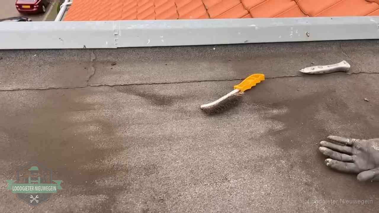 Kosten van daklekkage-reparatie in Nieuwegein Dakdekker bereidt een bitumen plat dak voor op reparatie bij de daktrim in Nieuwegein