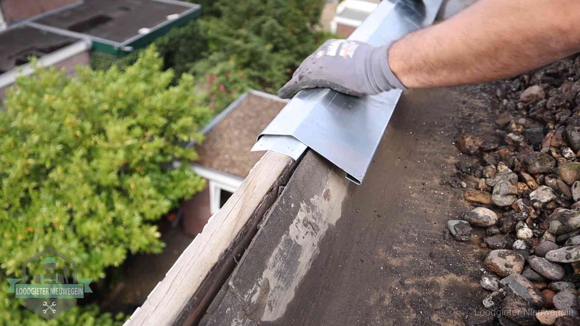 Daklekkage per wijk in Nieuwegein Dakdekker plaatst een zinken deklijst op een dakrand met uitzicht over een woonwijk in Nieuwegein