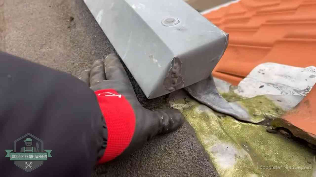 Hemelwaterafvoer en dakgoot controleren in Nieuwegein Controle van een zinken hemelwaterafvoer met loodslab bij dakpannen in Nieuwegein