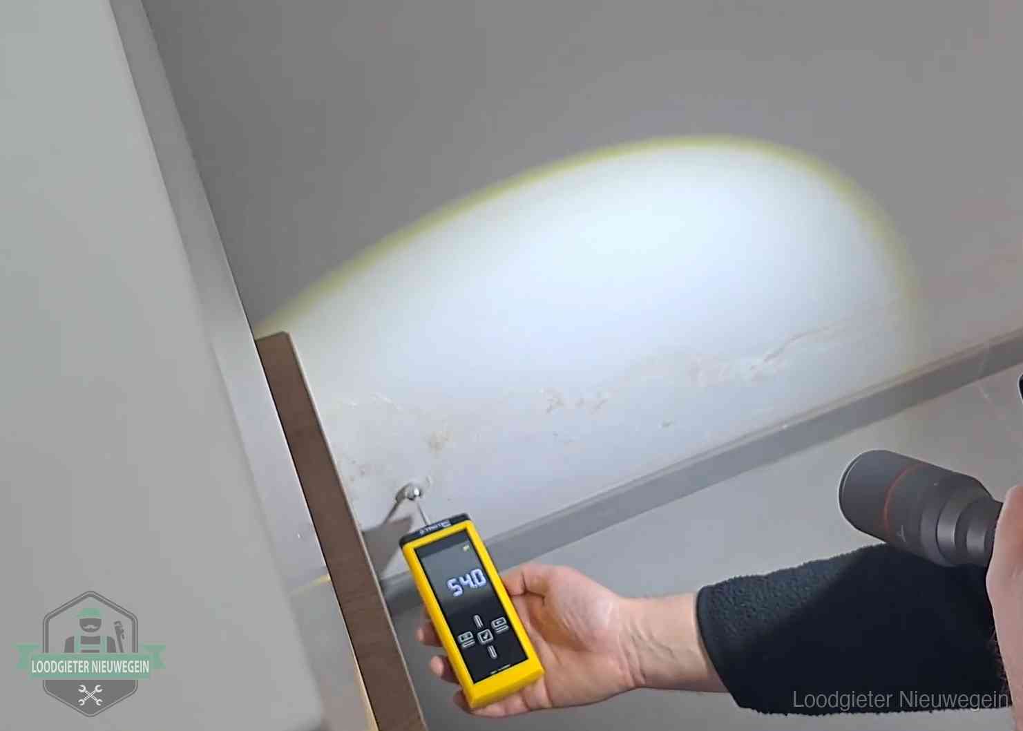 Vochtmeter tegen een natte wand met lekkagesporen in Nieuwegein