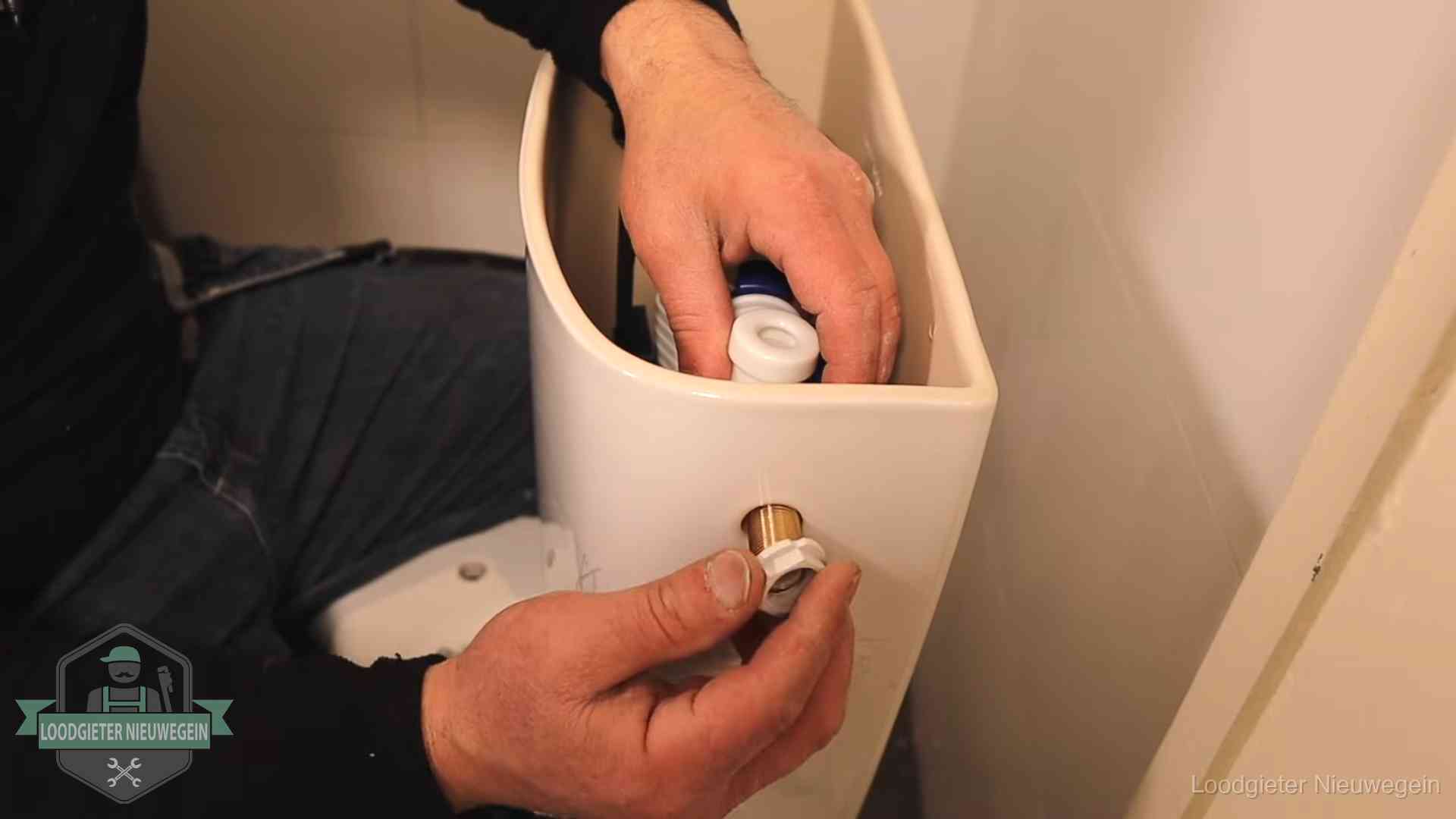 Loodgieter monteert de vlotterkraan van een stortbak bij een toilet in Nieuwegein
