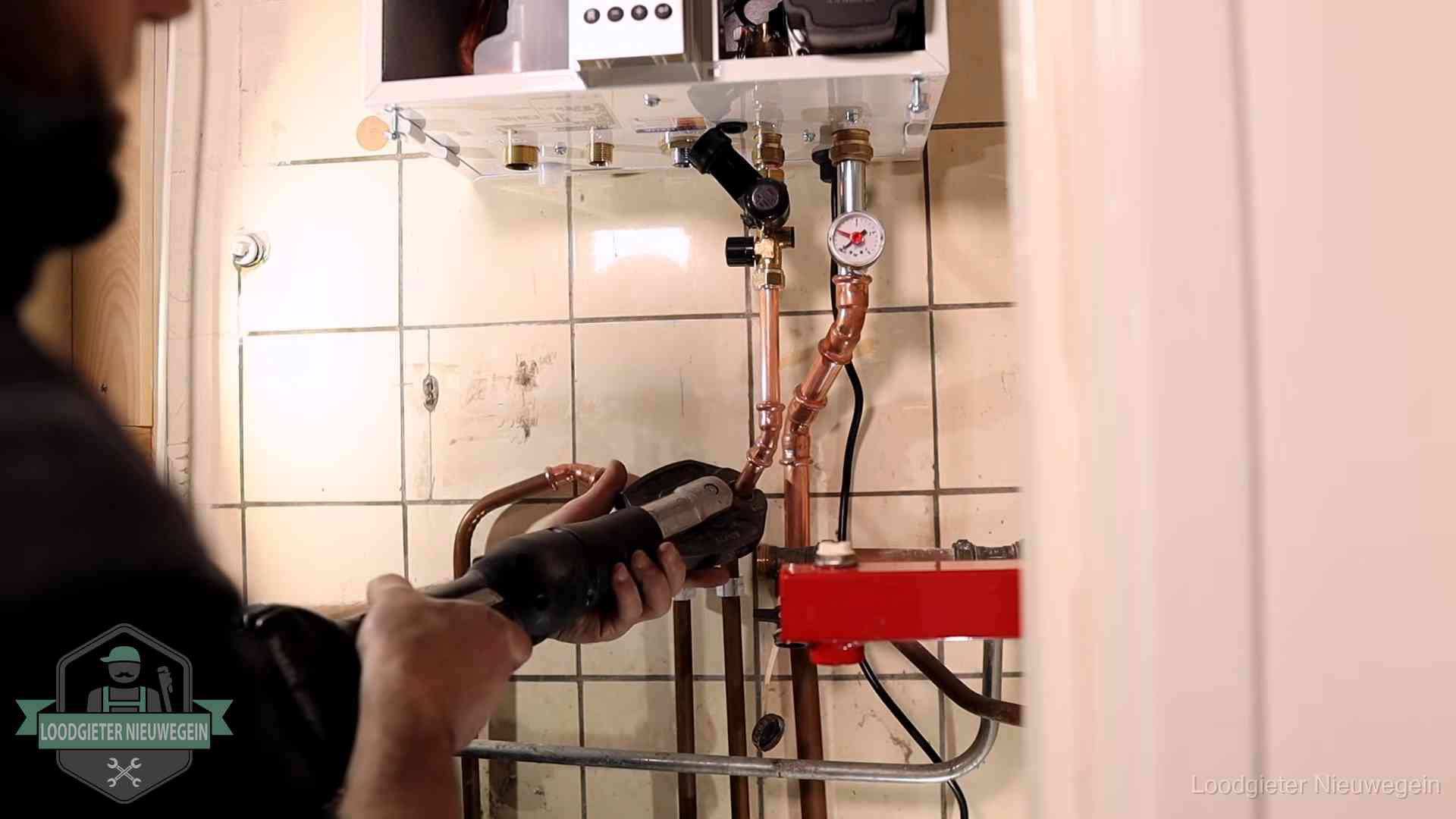 Monteur werkt aan de leidingen onder een cv-ketel in Nieuwegein