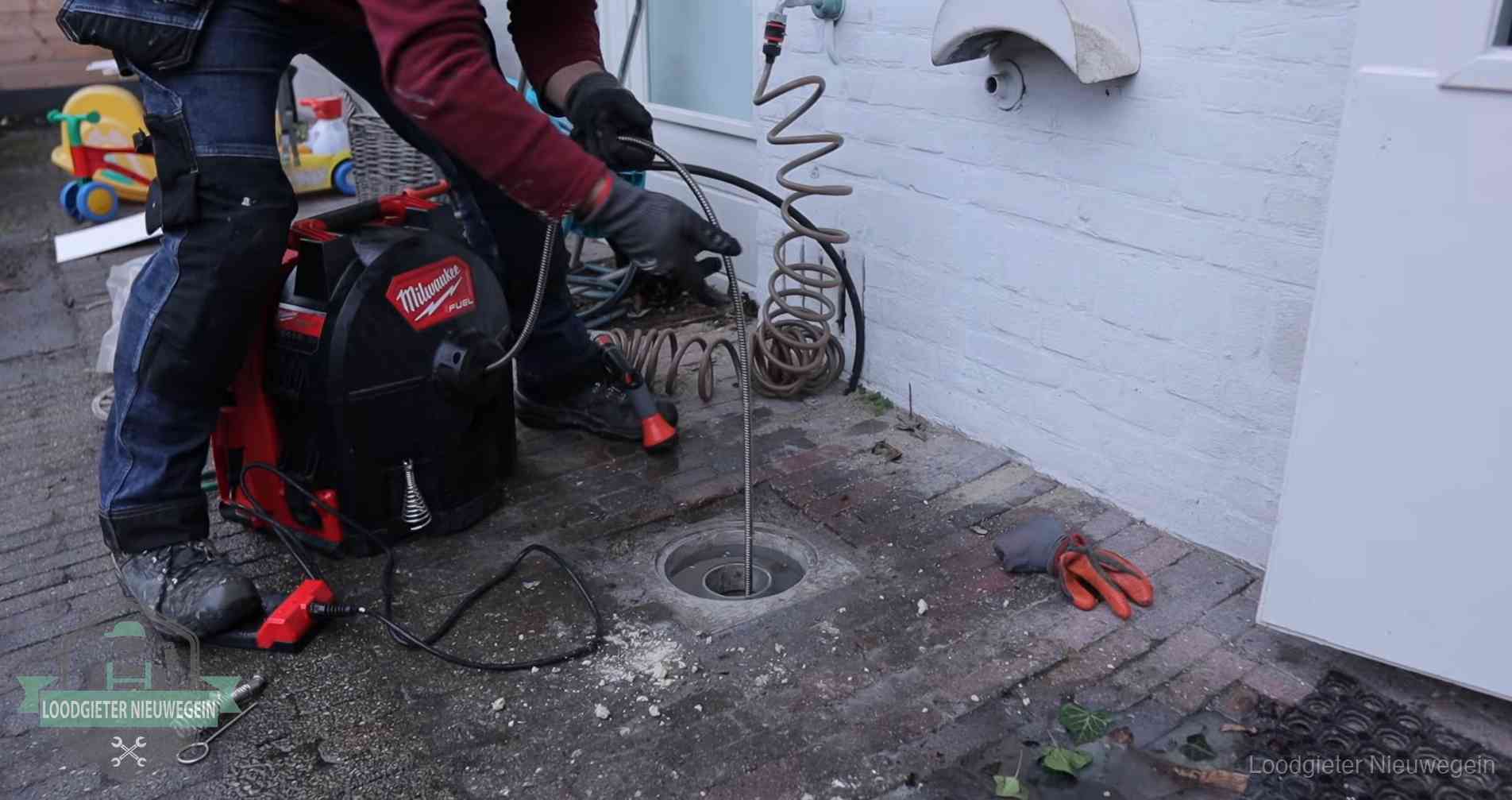 Ontstoppingsputje in de bestrating naast de gevel van een woning in Nieuwegein