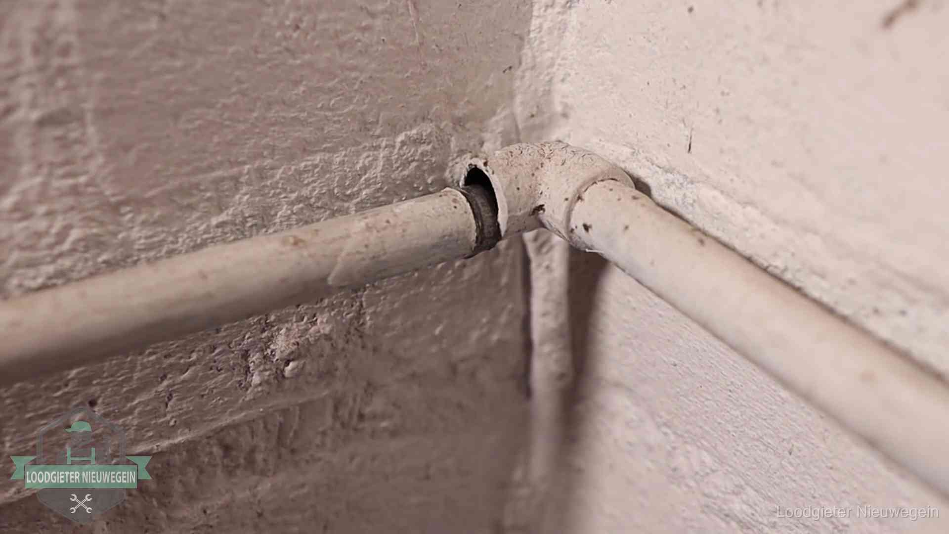 Oude geverfde waterleiding met een losliggende fitting in een woning in Nieuwegein