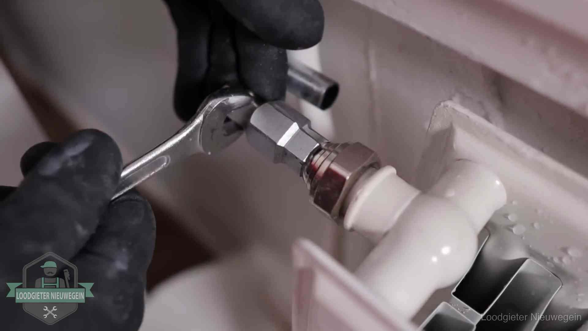 Steeksleutel draait een wartelkoppeling op een radiatorkraan aan in Nieuwegein