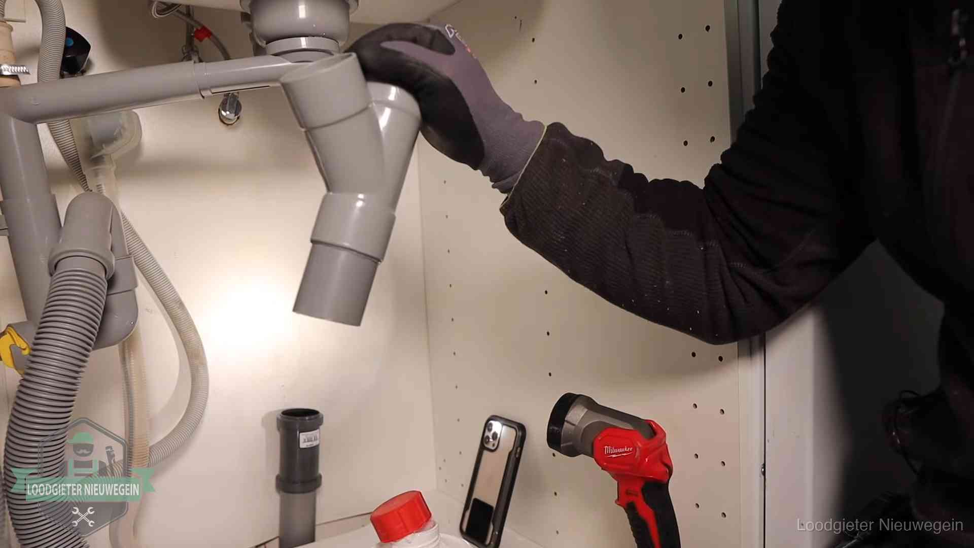 Loodgieter demonteert het sifon- en afvoerwerk onder een gootsteen in Nieuwegein bij stankklachten