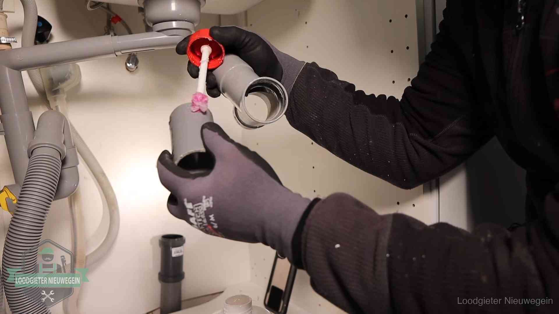 Loodgieter demonteert en reinigt de sifon onder een keukenkast in Nieuwegein
