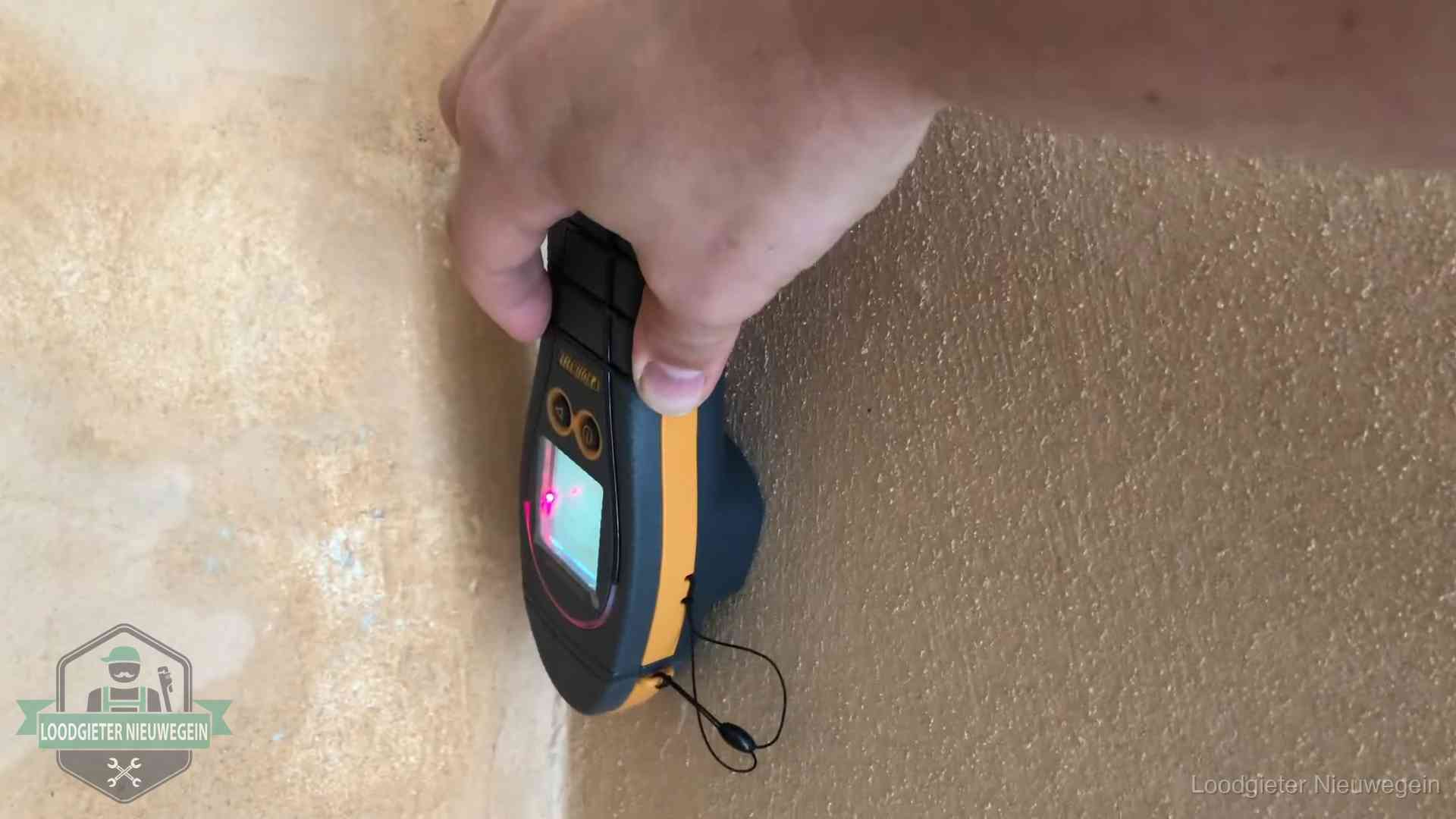 Daklekkage opsporen zonder hakwerk in Nieuwegein Vochtmeter tegen een muur met vochtplekken tijdens het opsporen van een daklekkage in Nieuwegein