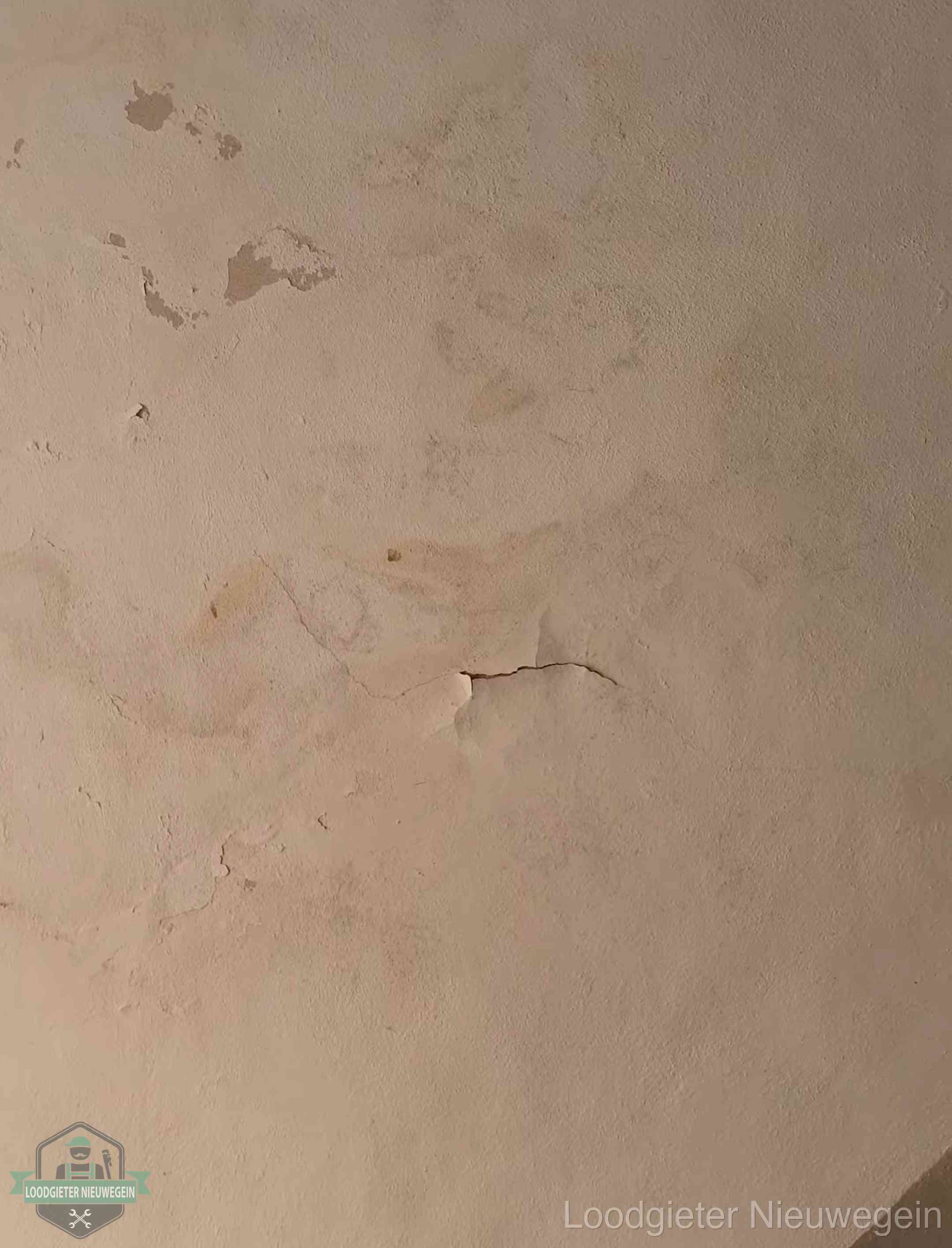 Vochtkringen en afbladderende verf op een plafond in Nieuwegein, schade voor het meetrapport en de verzekering