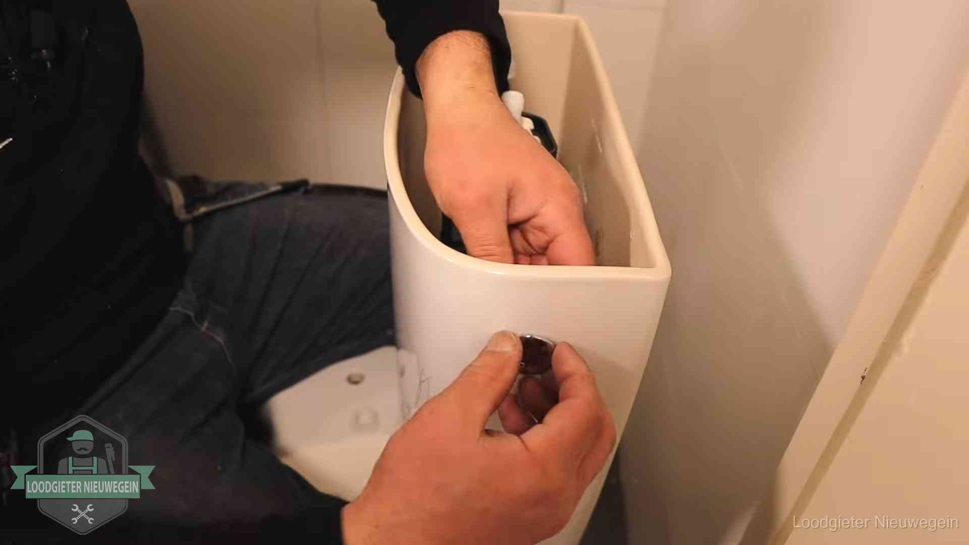 Drukknop van een duoblok-stortbak wordt gemonteerd bij een toilet in Nieuwegein